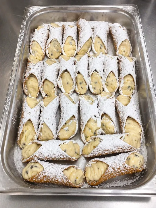 Cannoli siciliani farciti a mano con ricotta e gocce di cioccolato
