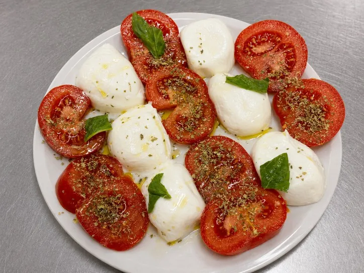 Caprese di pomodoro e mozzarella con origano e olio extravergine